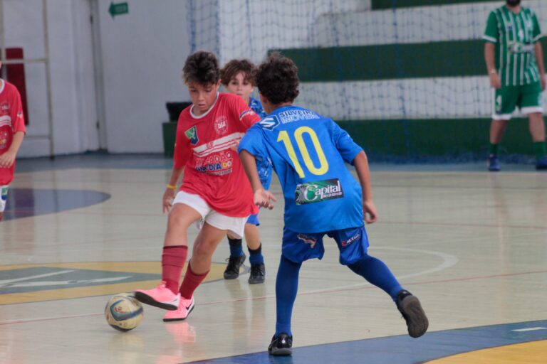 Jogador se preparando para chutar a bola com técnica e precisão, destacando os fundamentos essenciais do chute no futebol