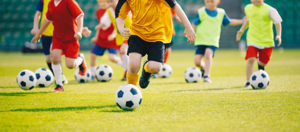 Jogadores em um torneio infantil de futebol, representando a busca precoce por destaque no futebol.