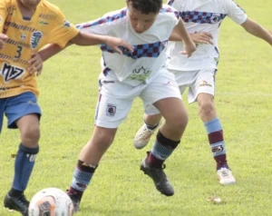 Crianças participando de um campeonato de alta performance do futebol infantil.