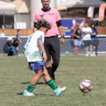 Jovem atleta Sub-12 em ação durante campeonato de futebol, representando foco e desenvolvimento emocional.