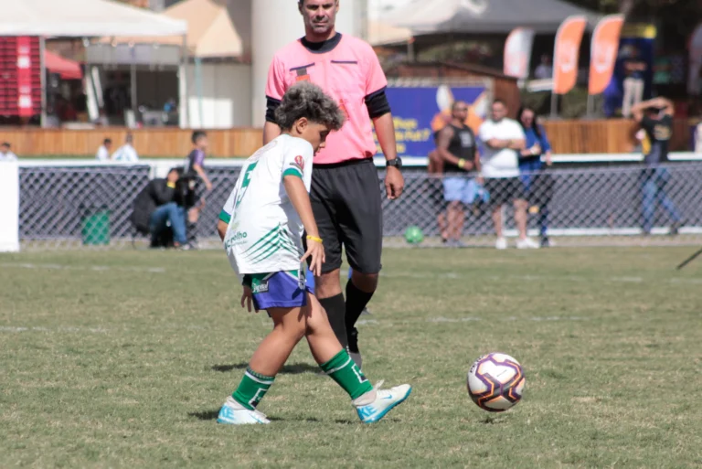 Jovem atleta Sub-12 em ação durante campeonato de futebol, representando foco e desenvolvimento emocional.
