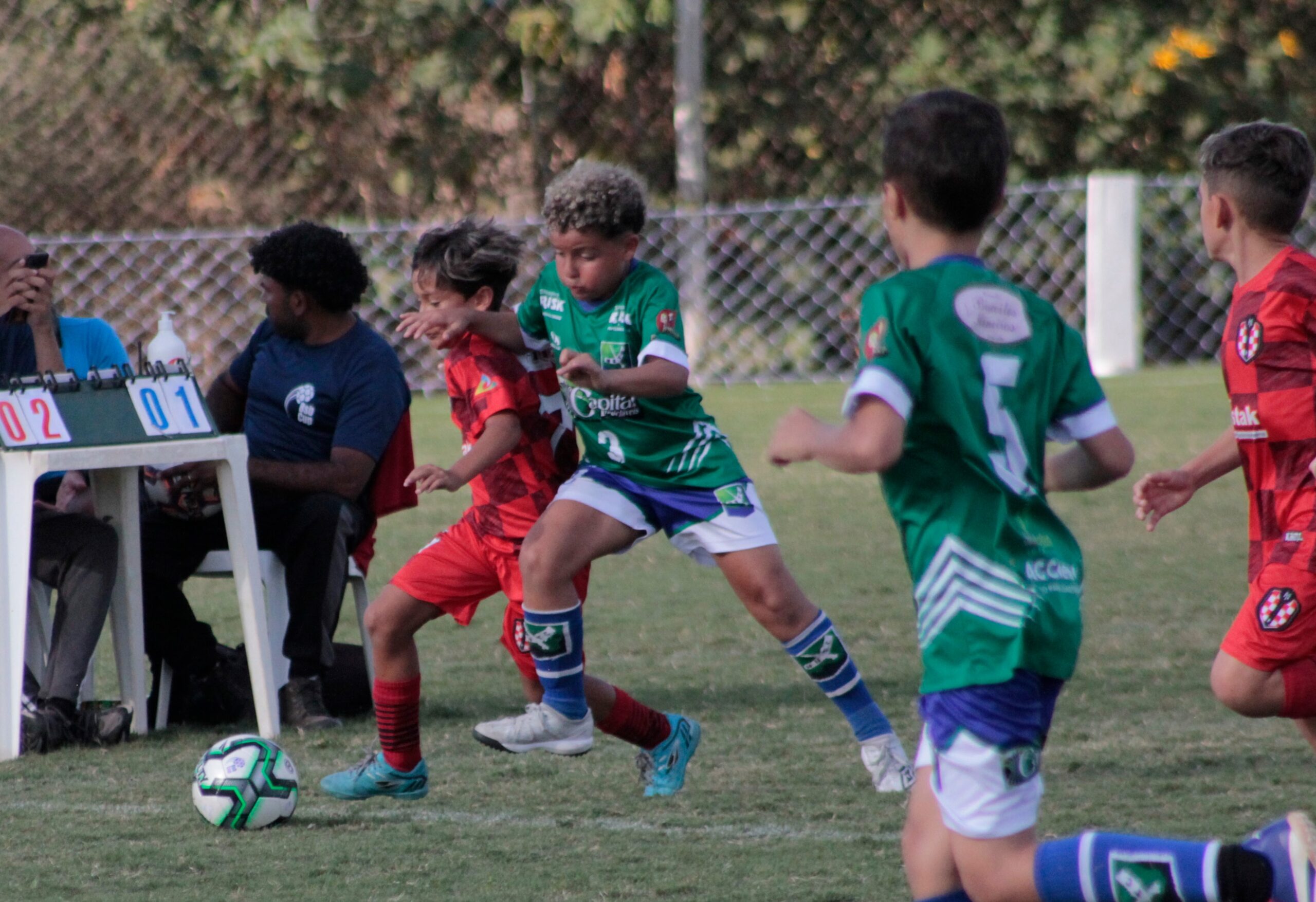 Crianças disputando partida de campeonato de futebol infantil