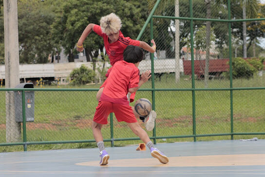 Duas crianças uma sub 08 e outra sub 12 disputando a bola em treino de futsal com respeito e espírito esportivo ensinamento basico fornecido por pais e treinadores.