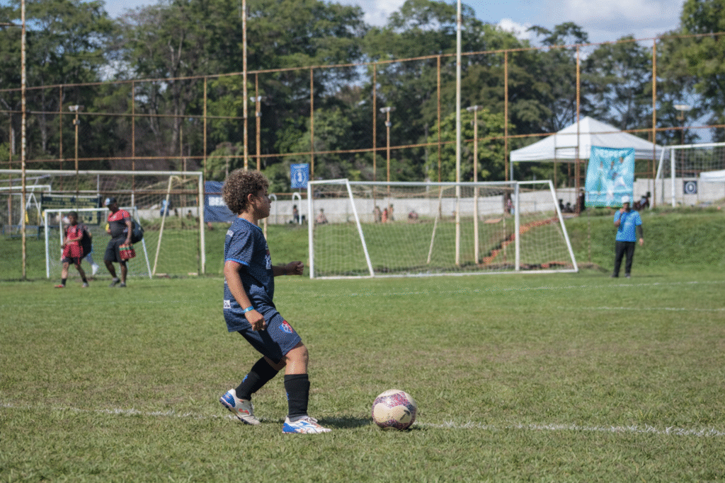 Criança no futebol infantil analisando o jogo antes do passe
